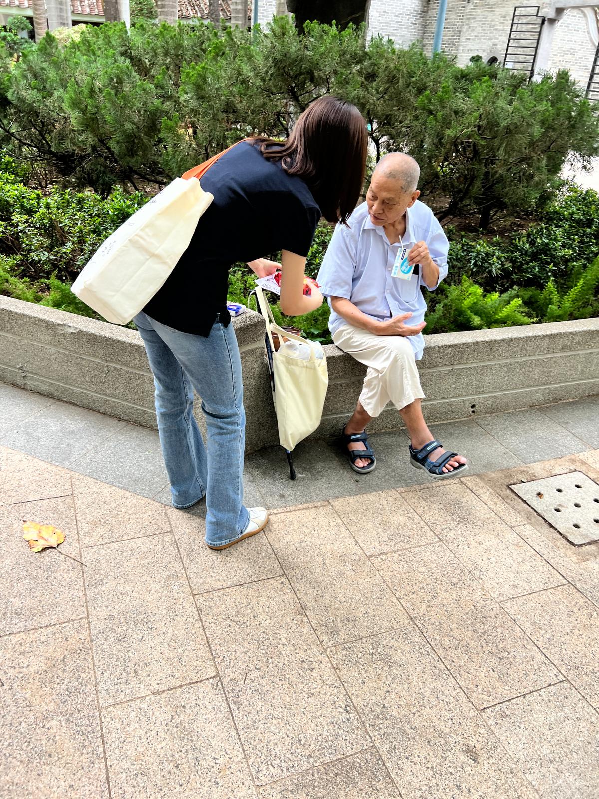 Volunteer speaking with an elderly man outdoors