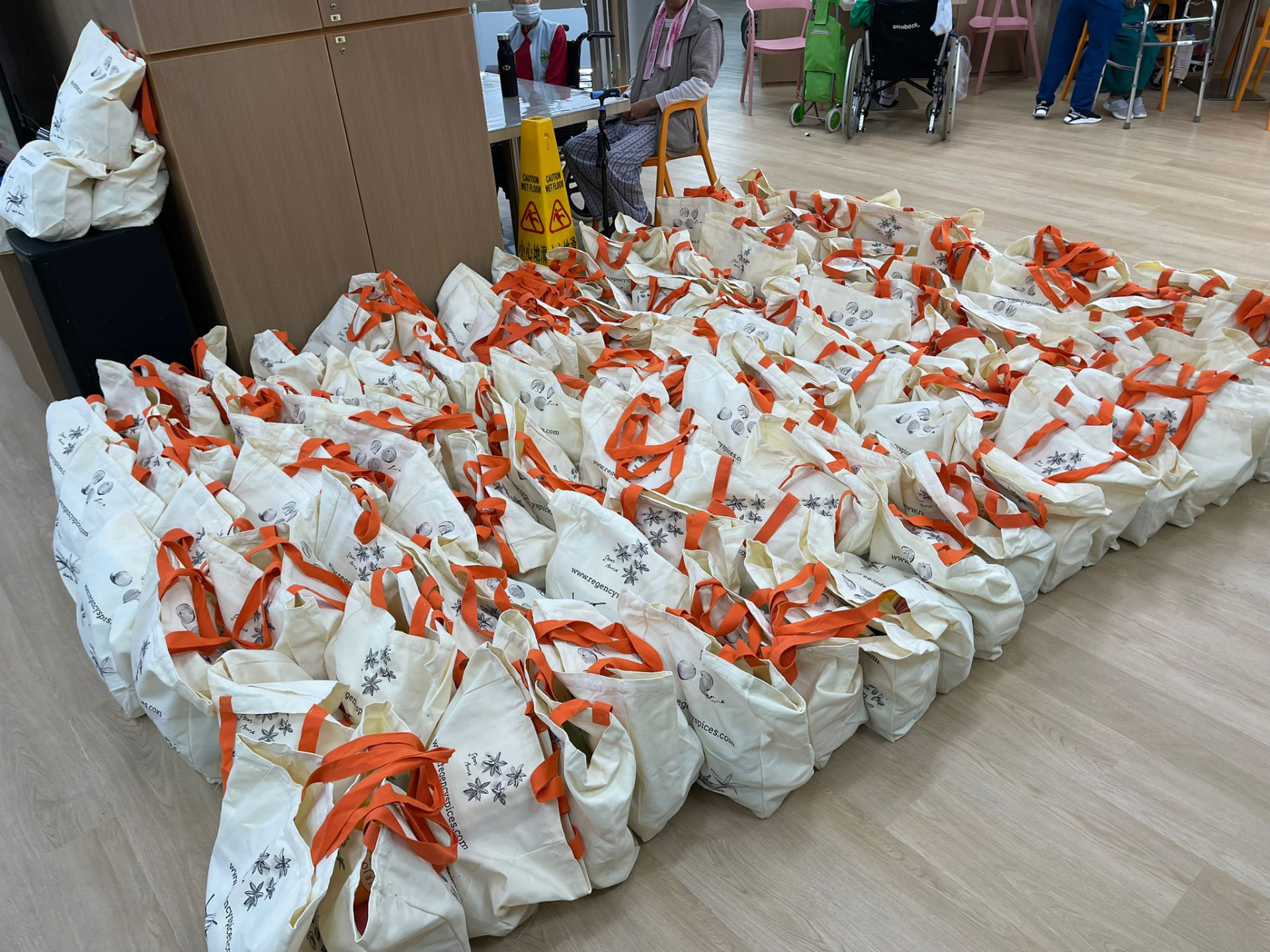 Rows of prepared tote bags on a community centre floor